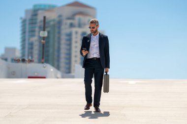 Zengin bir iş adamı dışarıda yürüyor. Çantası olan başarılı bir iş adamı. Lider harekete geçti. İş adamı güvenle yürüyor. Takım elbiseli bir iş adamı işe gidiyor. İş profesyoneli hareket halinde