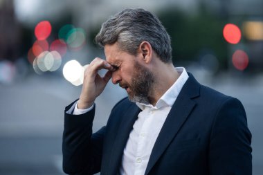 Gece şehrinde baş ağrısı çeken yorgun bir iş adamı. Migren ağrısını dindiren bir adam. Finansal sorunlar ve stres. İş krizi ve iflas kavramı. İş adamı endişeli ve stresli