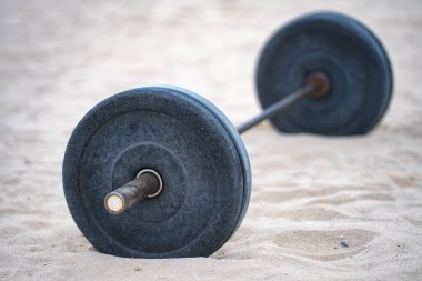 Barbell strength workout. Barbell training outdoors. Barbell exercise in the park. Barbell fitness background