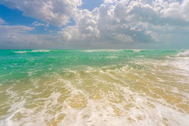 Okyanus dalgaları ve kum, yaz kıyı şeridi arka planı. Fırtınalı deniz dalgaları. Yaz denizi dalgası. Köpüklü okyanus dalgaları. Yaz okyanus esintisi. Rüya gibi yaz sahili geçmişi. Okyanus sıçrama dalgaları