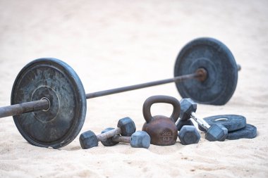 Kettlebell, dumbbells and barbell weights background. Bodybuilding with heavy weights. Sports scene with weights. Kettlebell, dumbbells and barbell background. Weights training outdoor