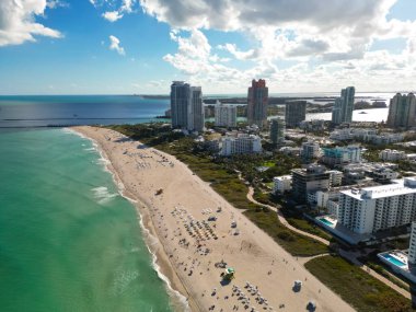 Aerial view of Miami Beach with blue sky. Drone shot of Miami skyline. Top view of South Beach. Miami cityscape with luxury skyscrapers and ocean. View of Miami famous coastline
