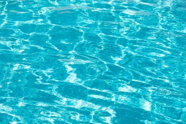 Mavi havuz suyu arka planı. Bulanık şeffaf, durgun su yüzeyi dokusu. Güneş ışığı altında su dalgaları kopyalama alanı ile