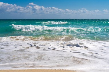 Tropik plaj. Güzel deniz deseni. Temiz su yüzeyi. Sakin okyanus hareketi. Dramatik fırtına dalgaları. Güneş ışığı kıyısı. Köpüklü dalga dokusu. Açık turkuaz deniz. Huzurlu tatil manzarası. Dalgalı okyanus