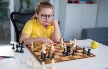 Evde satranç oynayan bir çocuk. Akıllı çocuk şah mat hareketine odaklanmış. Çocuk sınıf arkadaşıyla satranç oynuyor. Akıllı çocuk sınıfta satranç çalışıyor. Samimi bir satranç oyunuyla çocukluk anı