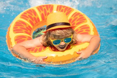 Çocuk yüzüyor ve havuzda oynuyor. Çocuk yüzme havuzunda oynuyor. Yaz tatili kavramı. Yaz Moda Çocukları portresi