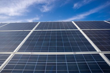 Mavi gökyüzündeki paneller. Yeşil yaşam için güneş çözümleri. Güneş enerjisi yenilenebilir. Güneş paneli ve güneş enerjisi. Paneller güneşin altında parlıyor. Güneş teknolojisi