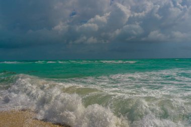 Deniz kıyısı. Renkli deniz kıyısı suyu. Sıcak okyanus esintisi. Yaz sahili. Deniz arka planı. Mavi okyanus. Kumsal. Okyanus dalgaları. Yaz mevsimi. Tropik sahil şeridi. Köpüklü dalga sıçraması