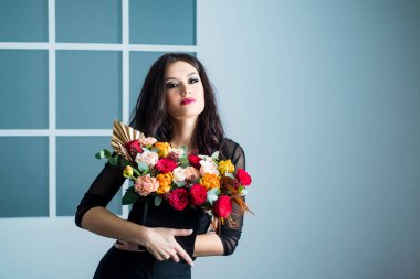 Güzel, şehvetli bir kadın. Çiçek buketi, stüdyo resmi.