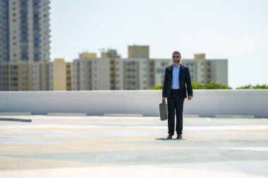 Successful businessman walk with on laptop outdoors. Confident business man hold laptop outside. Mature businessman in suit. Corporate business. Rich business man in suit. Outdoor business portrait