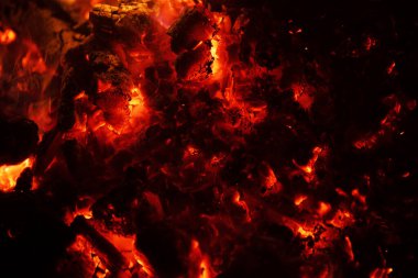 Yanan közler yangın arka planı. Yanan kömür dokusu. Sıcak kömürleri yakın çekim. Ateşli desen. Kırmızı sıcak küller parlıyor. Yanan közler makro. Ateş dokusu. Yangın arka planı. Parlayan kömür