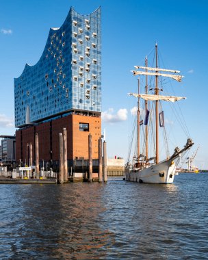 Elbphilharmonie cephesi ve uzun gemi direkleri. Hamburg Almanya 'sının turistik cazibe ve seyahat ikonu. Gemi ve mimarinin birleşiminden oluşan güzel bir şehir manzarası. Elbe Filarmoni Salonu