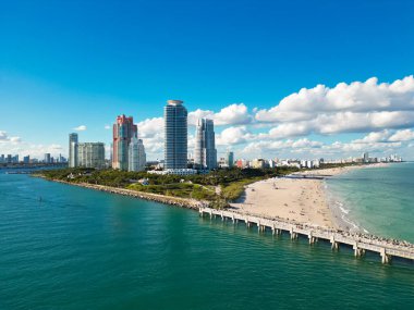 Miami 'de kumsalda güneşli yataklı, okyanus dalgalı bir plaj. Muhteşem manzaralı Miami Beach cenneti. Güney Sahili Miami cankurtaranı. Miami 'de huzurlu bir deniz kenarı inzivası. Kıyı gevşemesi