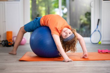 Mutlu çocuk evde spor yapıyor. Küçük şirin çocuk sabah sporu yapıyor. Genç sporcu çocuk odada egzersiz yapıyor. Çocuk antrenmanı. Çocuklar spor anlayışı. Çocuk evde spor yapmayı seviyor.