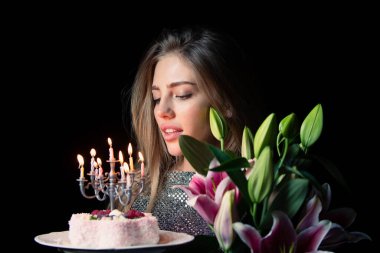Güzellik mankeni doğum gününü çiçekler ve pastayla kutluyor. Model doğum günü kutlaması. Güzel bayan elinde buket ve şenlikli tatlı tutuyor. Romantik doğum günü. Pembe zambaklı ve doğum günü pastalı kız.