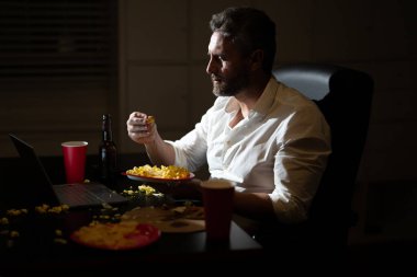 İş adamı fazla mesai yapıyor. Akşam yemeği yiyen ve internette çalışan meşgul bir adam. Milenyum girişimcisi bir şeyler atıştırırken gece geç saatlere kadar çalışır. Uzak bir ofis çalışanı yemek yiyor.