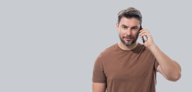 Stüdyonun arka planında izole edilmiş cep telefonu kullanan adam. Adam aramalar için akıllı telefon kullanıyor, sosyal medya, mobil uygulama. Telefonda konuşan adam. Başlık için afiş, kopyalama alanı. Ağ için poster