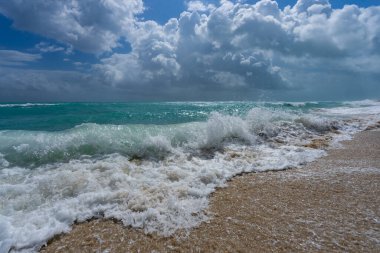 Turkuaz deniz dalgası hareketi. Yaz plajı. Sakin deniz. Lüks sahil beldesi. Parlak gökyüzü ve sahilde dalgalar. Güzel köpüklü kıyı şeridi. Deniz arka planı. Mavi okyanus. Kumsal. Deniz dalgaları