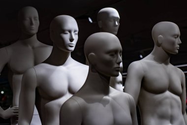 Bir grup erkek manken dramatik ışıkla aydınlatılıyor. Sanatsal sahne soyut insan formunu sembolize ediyor. Gölgeli ve derinlikli moda kompozisyonu