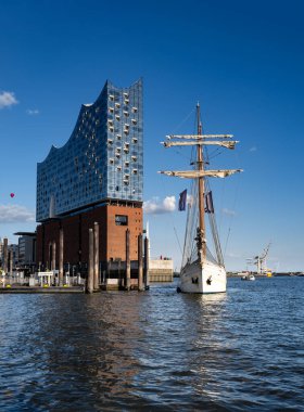 Elbe Filarmoni Salonu. Hamburg 'da Elbphilharmonie ve yelkenli gemisi. Hamburg 'daki modern konser salonu. Hamburg Limanı 'nda güneşli güzel bir gün. Hamburg 'da Elbe Suyu' nda gemi