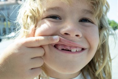 Dişleri dökülmüş gülümseyen bir çocuk. Diş boşluğu gösteren bir çocuk. Bebek dişlerinin kapanışı. Çocuğun süt dişleri dökülüyor. Çocuk ağzı ve yeni dişler. Dişsiz gülüşlü çocuk. Çocuklar dişlerini kaybetti. Çocuk diş konsepti