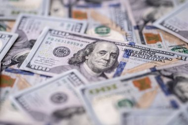 100 dolarlık banknotları olan para geçmişi. Amerikan para biriminin dokusu. 100 dolarlık banknotlar. Masaya yayılmış yüz dolarlık banknotlar. Finans kavramı için Amerikan dolarları deseni