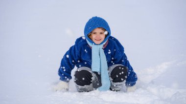 Noel kartı için sevimli bir çocuk. Şenlikli kış sahnesi. Çocuk kış portresi. Noel karlı çocuğu. Kış çocuğu suratı. Çocuk karlı günün tadını çıkarıyor. Tatil kış teması
