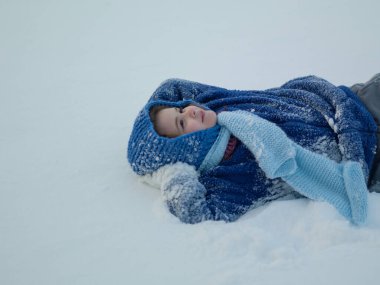 Kış tatili macerasında komik çocuk. Çocuklarla kış yolculuğu. Karlı kış gününde oynayan bir çocuk. Mutlu çocuk kar yağarken eğleniyor. Çocuk dışarıda kar yağışıyla oynuyor. Çocuklar için kış aktiviteleri