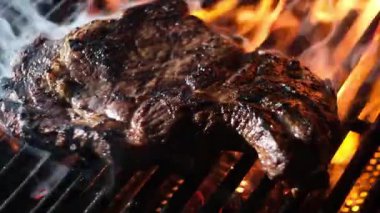 Izgarada ateşte pişmiş et. Biftek ızgarada, yakın plan. Izgara ızgara. Çiğ biftek ızgarası. Izgara et ve ateş. Sigara ve ızgarada ızgara sığır eti. Barbekü Mutfağı