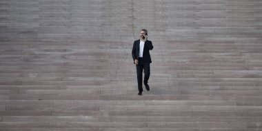 İşadamı merdivenlerden yukarı çıktı. Profesyonel büyüme ve başarıya doğru adım atan bir adam. Adım adım kariyer başarısına doğru. İşadamı merdivenleri çıkıyor. İş hedeflerine adım at