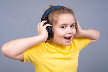 Çocuk kulaklıkla şarkı söylüyor. Çocuk sesten hoşlanıyor. Çocuk kulaklıkla rahatlıyor stüdyo izole edilmiş portresi. Müzik çocukları havasında. Sevimli gençler melodileri dinler. Gençler kulaklıkla gülümsüyor.