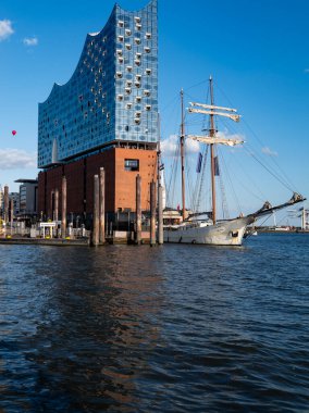 Elbphilharmonie cephesi ve uzun gemi direkleri. Hamburg Almanya 'sının turist ve seyahat ikonu. Hamburg 'da gemi ve mimarinin birleştiği şehir manzarası. Elbe Filarmoni Salonu