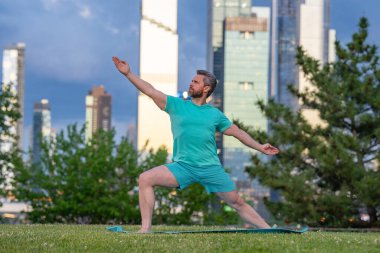 Güç için yoga. Sakin sakin nefes al. Atletik denge çalışması. Esnek atlet pozu. Doğa şehri eğitimi. Açık hava rutini. Dengeli vücut kontrolü