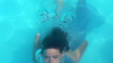 Suyun altında yüzen bir kızla yaz tatili. Temiz mavi suda yüzen bir kız. Gençler kabarcıklarla suyun altında yüzüyor. Havuzda şnorkelle yüzen kız. Yüzen kız sualtı görüntüsü