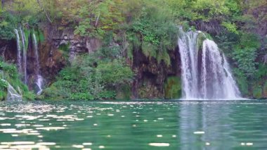 Kristal sular dağ vadisinde akıyor. Şelale cennetinde huzurlu bir yolculuk. Doğadaki şelalelerin güzelliği. Plitvice Ulusal Parkı. Bir dağ şelalesinin serinletici serinliği