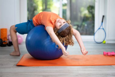 Evde spor yapan bir çocuk. Sportif çocuk evde spor yapıyor. Çocuk evde spor yapıyor. Çocuk sağlıklı bir yaşam için vücudunu esnetiyor. Çocuk spordan zevk alıyor. Çocuk sporu kondisyonu