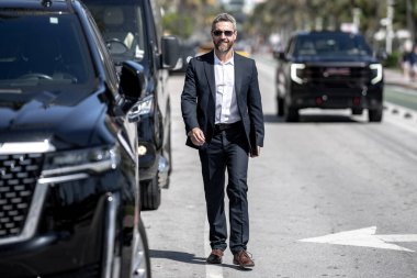 Lüks bir arabanın yanında zengin bir işadamı. Açık havada başarılı bir iş adamı. Zarif zengin iş adamı. Pahalı arabası olan bir patron. Premium bir arabanın önünde duran bir iş adamı. İş başarısı