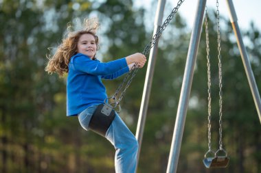 Çocuk salıncakta eğleniyor. Çocuk bahçesinde mutlu bir çocuk. Kaygısız çocuk dışarıda sallanıyor. Mutlu çocuklar dışarıda oynuyor. Sarışın çocuk heyecandan titriyor. Dışarıdaki oyuncu çocuk. Eğlenceli çocuk suratı