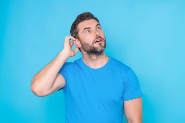 Stüdyonun izole edilmiş arka planında kafası karışmış düşünen bir adamın portresi. Düşünen adam, düşünceli yüz, düşünceli yüz. Şüpheli bir kavram. Ciddi ifade, şüphe ve seçim