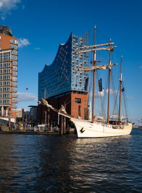 Elbphilharmonie cephesi ve uzun gemi direkleri. Hamburg Almanya 'sının turist ve seyahat ikonu. Gemi ve mimarinin birleşiminden oluşan güzel bir şehir manzarası. Elbe Filarmoni Salonu