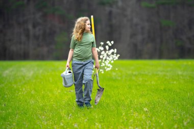 Çocuk bahçeye bahar ağacı dikiyor. Çocuklar meyve ağacı gibi büyür. Kürekli çocuk bahçıvan. Çocuk meyve bahçesinde çiçek açan ağaçlarla çalışıyor. Çocuklar arka bahçeye ağaç dikiyorlar. Ağaçlarla ilgilenen genç çiftçi