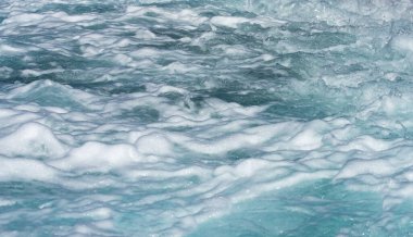 Dalgalar okyanus dokusunda. Okyanus dalgaları hareket ediyor. Okyanus enerjili köpüklü deniz dalgası. Tropik güneş ışığında deniz dalgaları. Kristal dalga ışığı yansıtır. Deniz dalgaları kıyıda kıvrılır ve kırılır