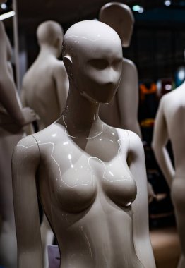 Modern mağazada parlak bir manken vücudu. Kadınsı tasarımın yansıtıcı sanatı. Soyut perakende satış konsepti. Moda butiğindeki yumuşak plastik figür. Işık ve şekilli en düşük bileşim