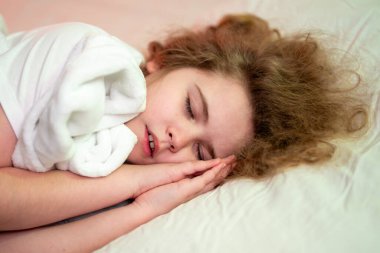 Çocuk yatakta rahat uyuyor. Çocuk uyuduğu an. Çocuk evde uyuyor. Çocuk derin uykuda tatlı tatlı uyuyor. Çocuk sakin bir gece atmosferinde uyuyor. Çocuk rahat bir uyku ortamı