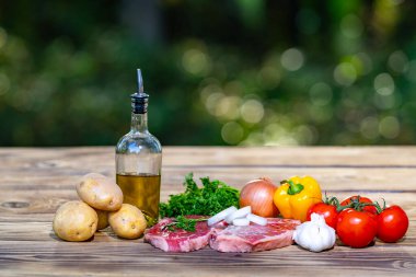 Tahta masada sarımsaklı çiğ biftek ve soğan. Izgara ya da barbekü için taze et dilimi hazır. Biftek tarifi için. Çiğ biftek ve sebze. Gemide taze et var.