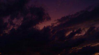 Güneş batıyor, bulutlar mavi ve turuncu dramatik gökyüzünde, güneş ışınlarıyla. Gece Günbatımı Gökyüzü zaman ayarlı. Gün batımında hareket eden bulutlar. Akşam bulutları. Alacakaranlık alacakaranlık gökyüzü zaman aşımı. Dramatik gökyüzü