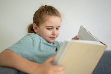 Çocuk açık bir kitapla rüya görüyor. Çocuk evde kitap okuyor. Küçük öğrenci kitap tutuyor. Kitaplarla gülümseyen sevimli bir çocuk. Çocuk pencerenin yanında kitap okuyor. Çocuk en sevdiği kitapları seviyor.