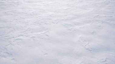 Karlı, donmuş arka plan ve kar taneleri. Doğal don desenli beyaz kar yüzeyi. Kış soğuğu dokusu ve köpüklü kar. Karlı bir arazi. Donmuş arkaplan beyaz kar ile