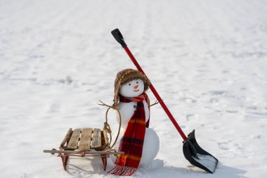 Winter mood snowman scene. Winter design with snowman and shovel. Winter vibes with cute snowman and sled. Winter outdoor scene with snowman