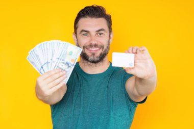 Adam sarı stüdyonun arka planına para koydu. Parası olan zengin bir adam. Dolar banknotları olan başarılı bir adam. Zengin milyoner.